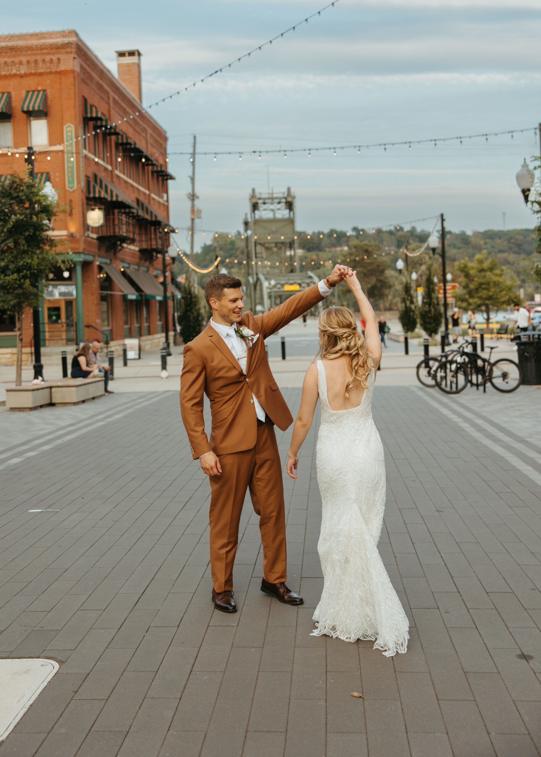 Wedding couple posing on the Stillwater Lift Bridge with the historic downtown buildings and Loft 214 visible in the background