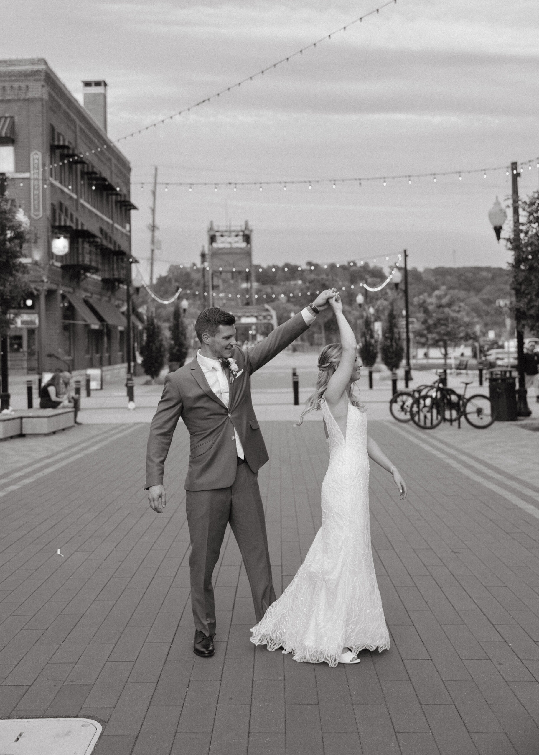 Wedding couple posing on the Stillwater Lift Bridge with the historic downtown buildings and Loft 214 visible in the background