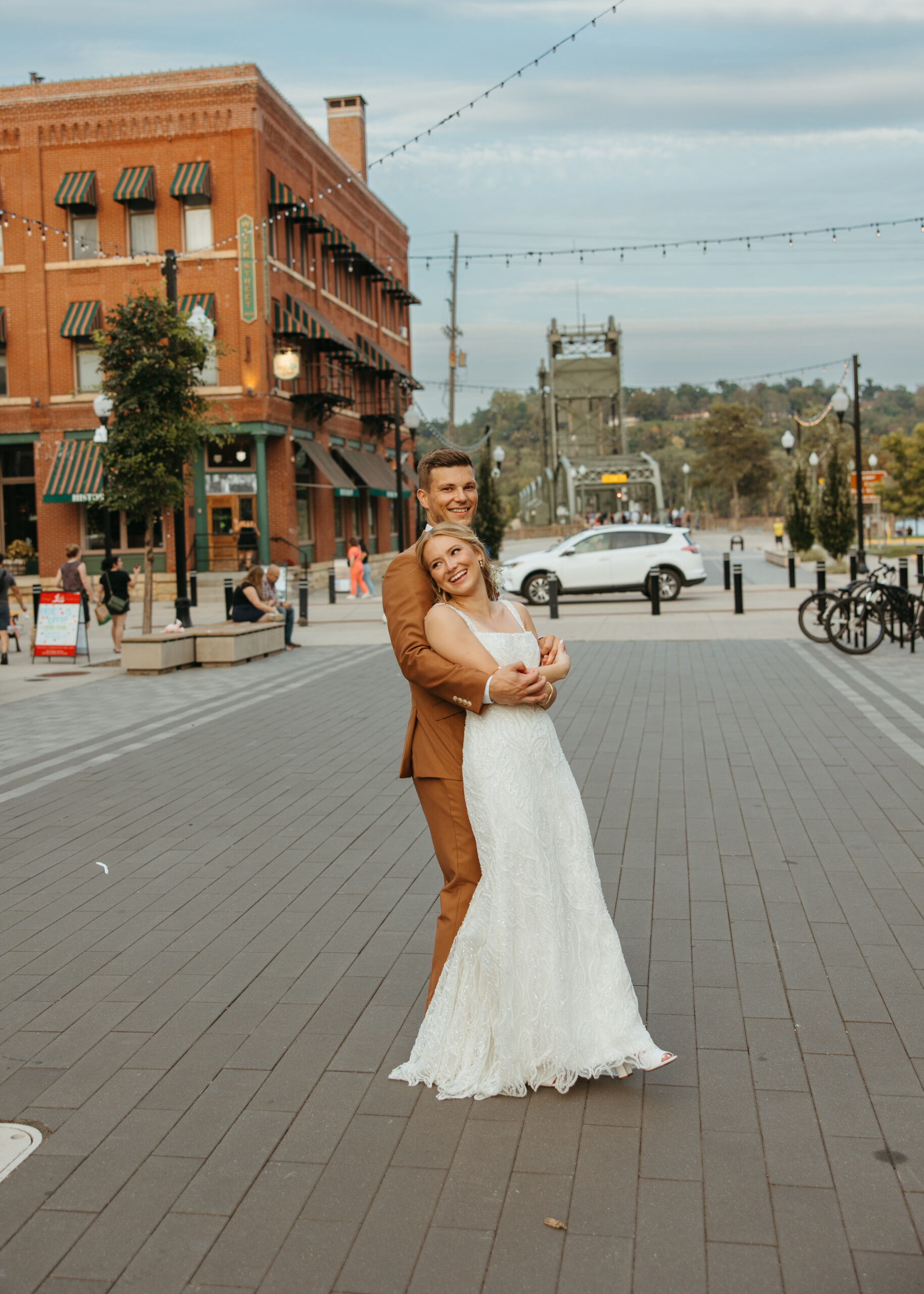 Wedding couple posing on the Stillwater Lift Bridge with the historic downtown buildings and Loft 214 visible in the background