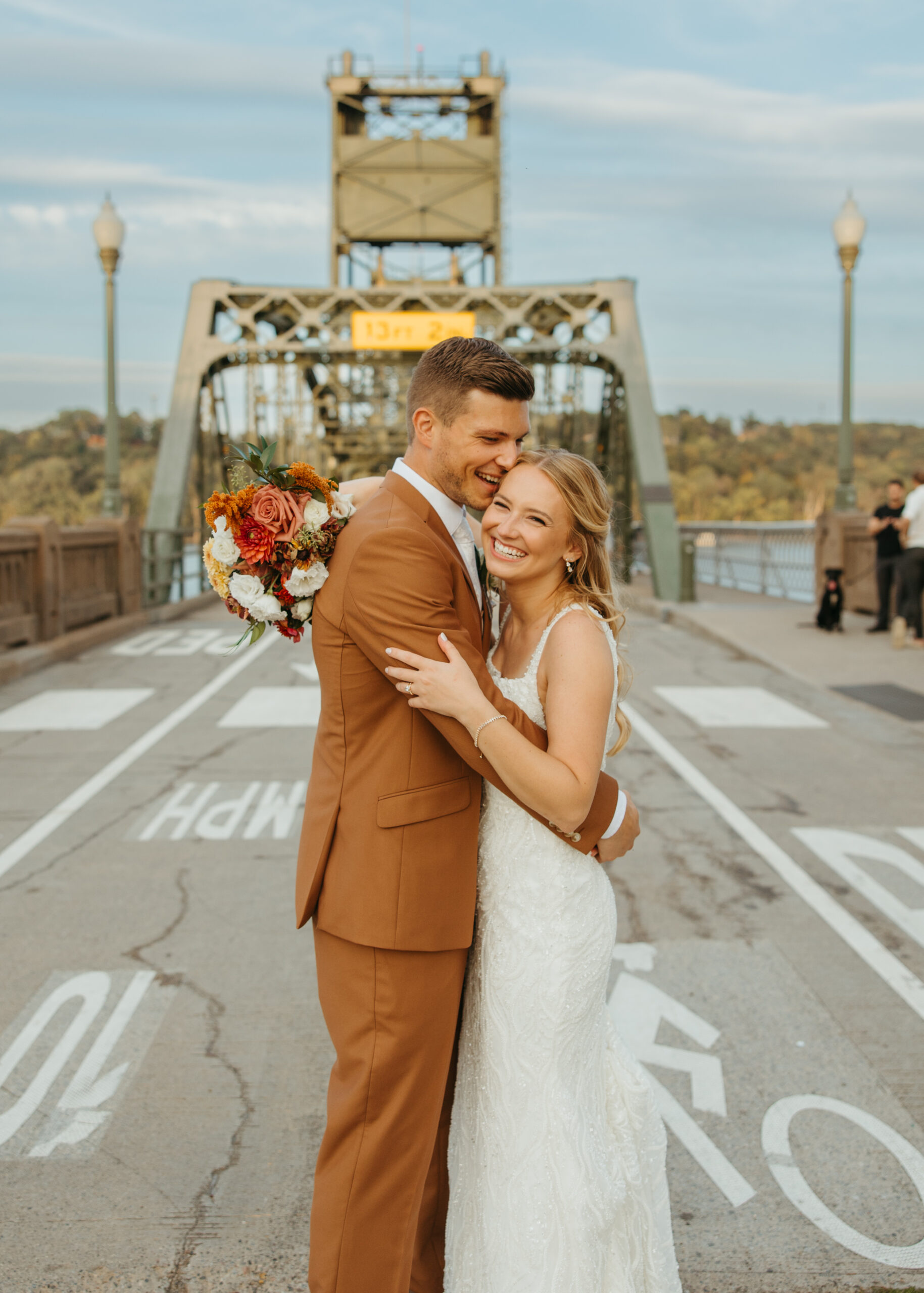 Wedding couple posing on the Stillwater Lift Bridge with the historic downtown buildings and Loft 214 visible in the background