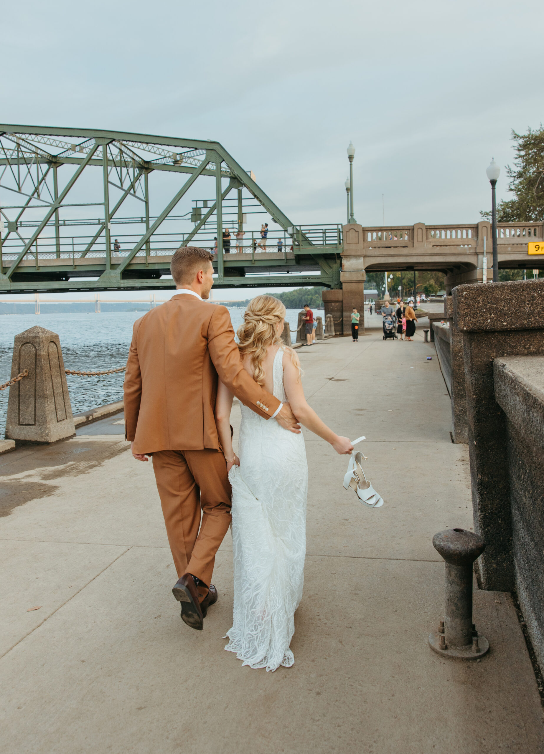 Wedding couple posing on the Stillwater Lift Bridge with the historic downtown buildings and Loft 214 visible in the background