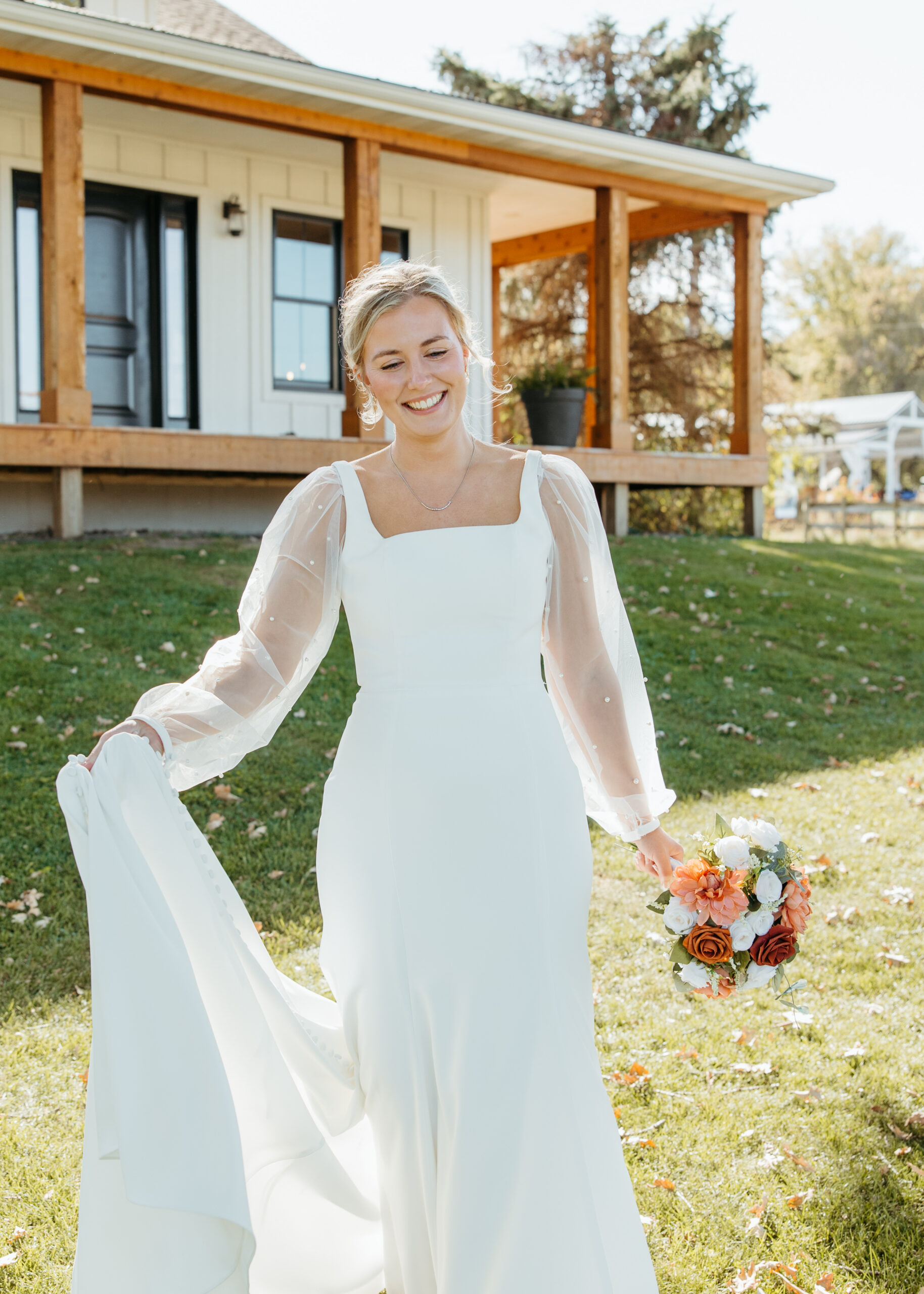Professional Minneapolis wedding photography showing a beautiful bride in a sheer, long-sleeve pearl wedding dress at Genesis Ranch, styled by D'Amore Wedding and Event Planning.