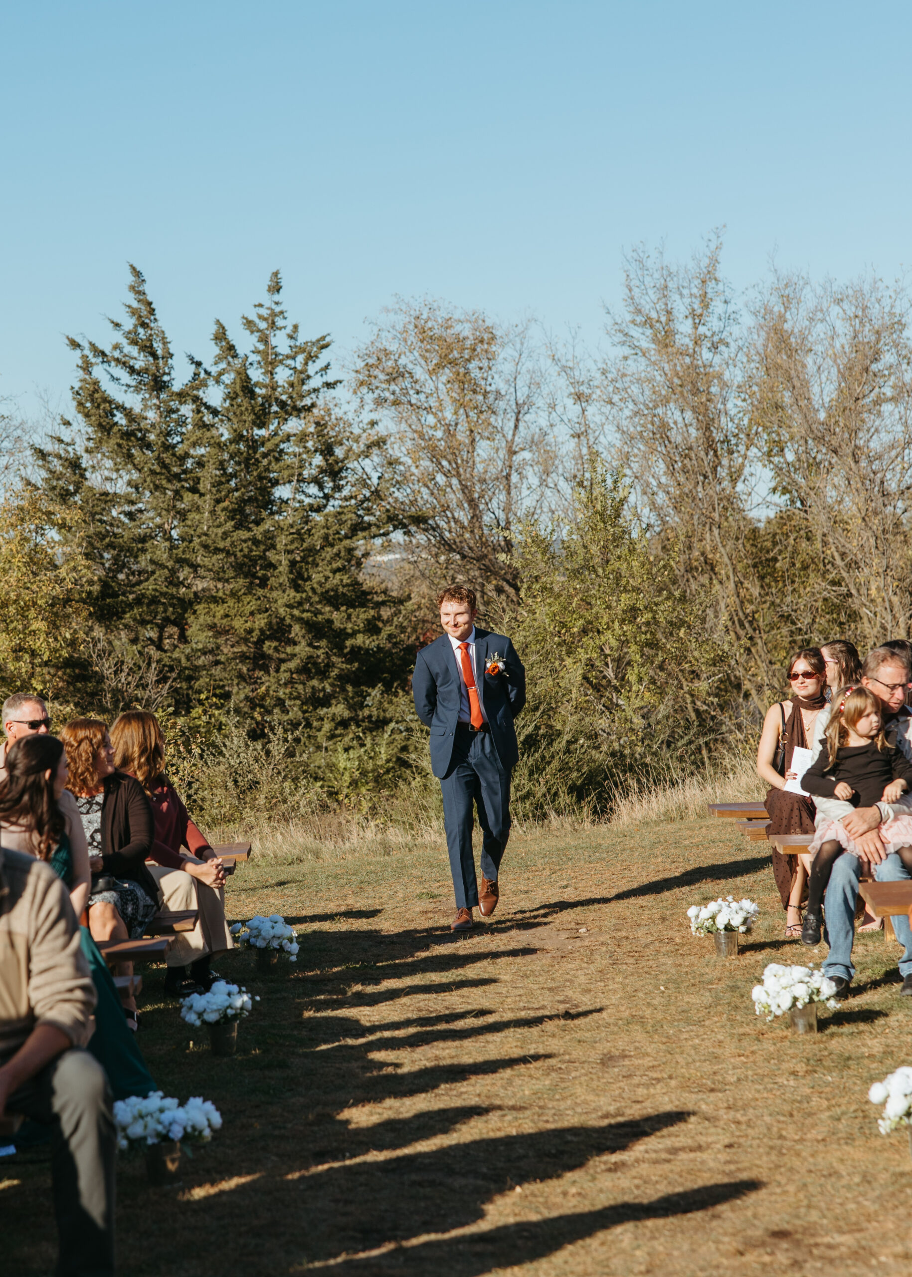 Professional Minneapolis wedding photography capturing the groom's ceremony entrance at Genesis Ranch, perfectly timed by D'Amore Wedding and Event Planning