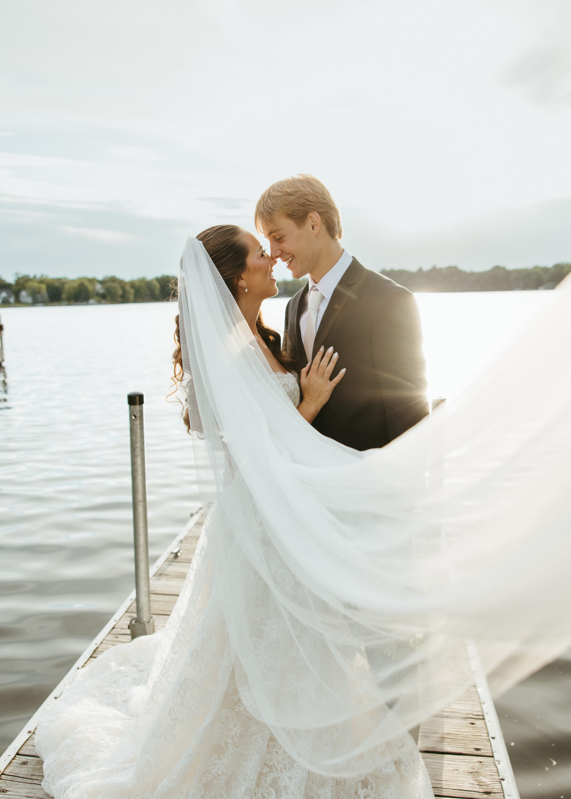Bride in effortless attire from The Visionary Bride and groom standing along the shore at a Minneapolis lake.