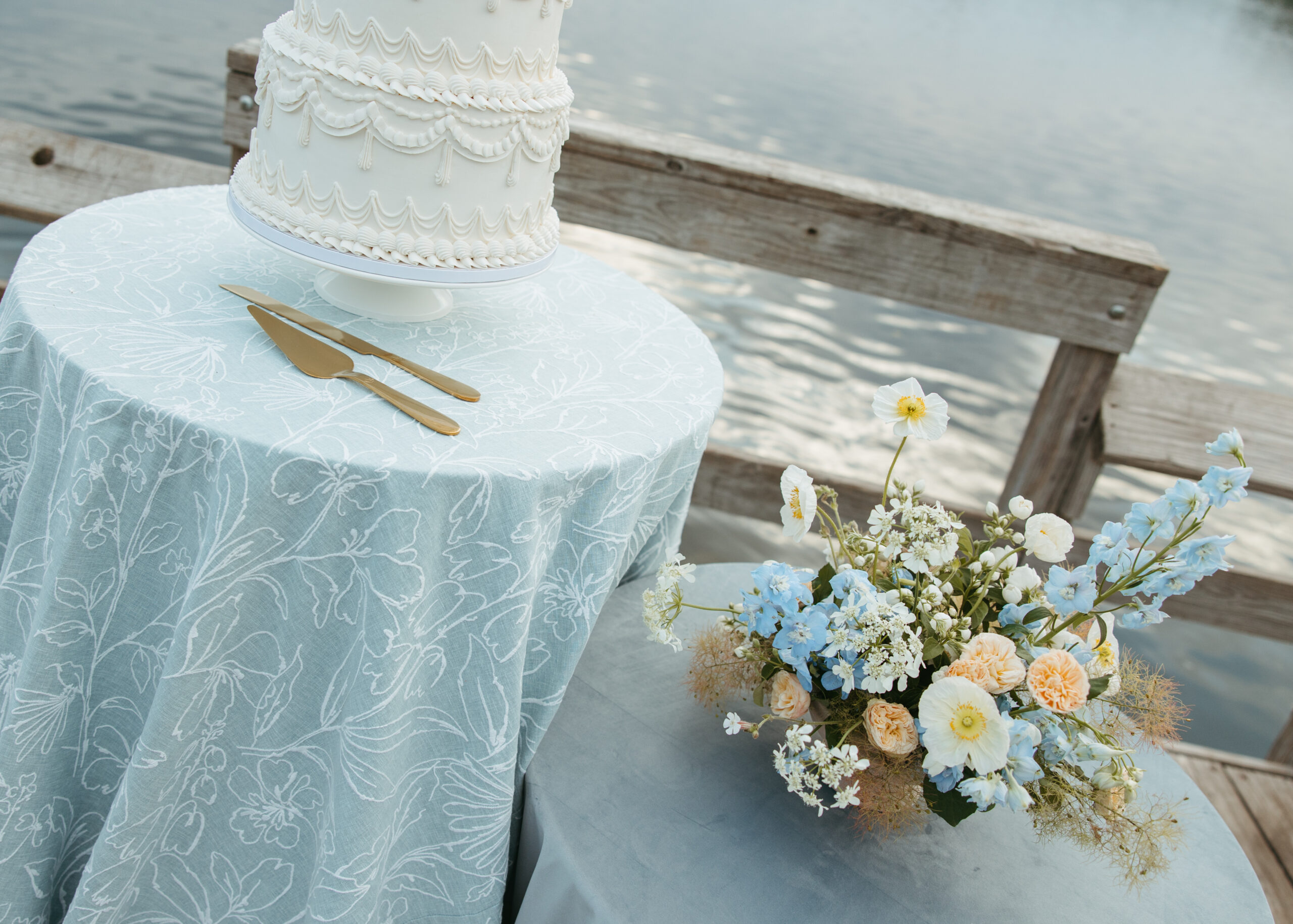 Coastal inspired lakeside wedding table setup with soft blue linens and white floral arrangements for a Minneapolis wedding.