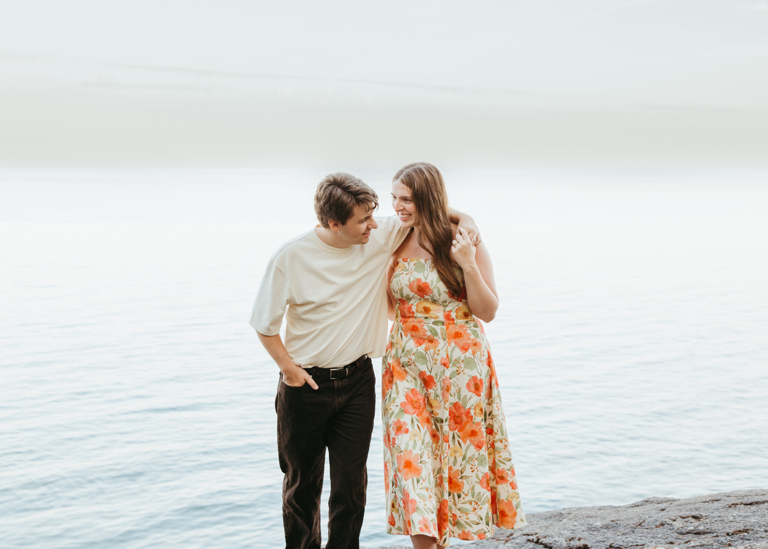 Couple posing on the rocky shore of Lake Superior in Lutsen, MN.