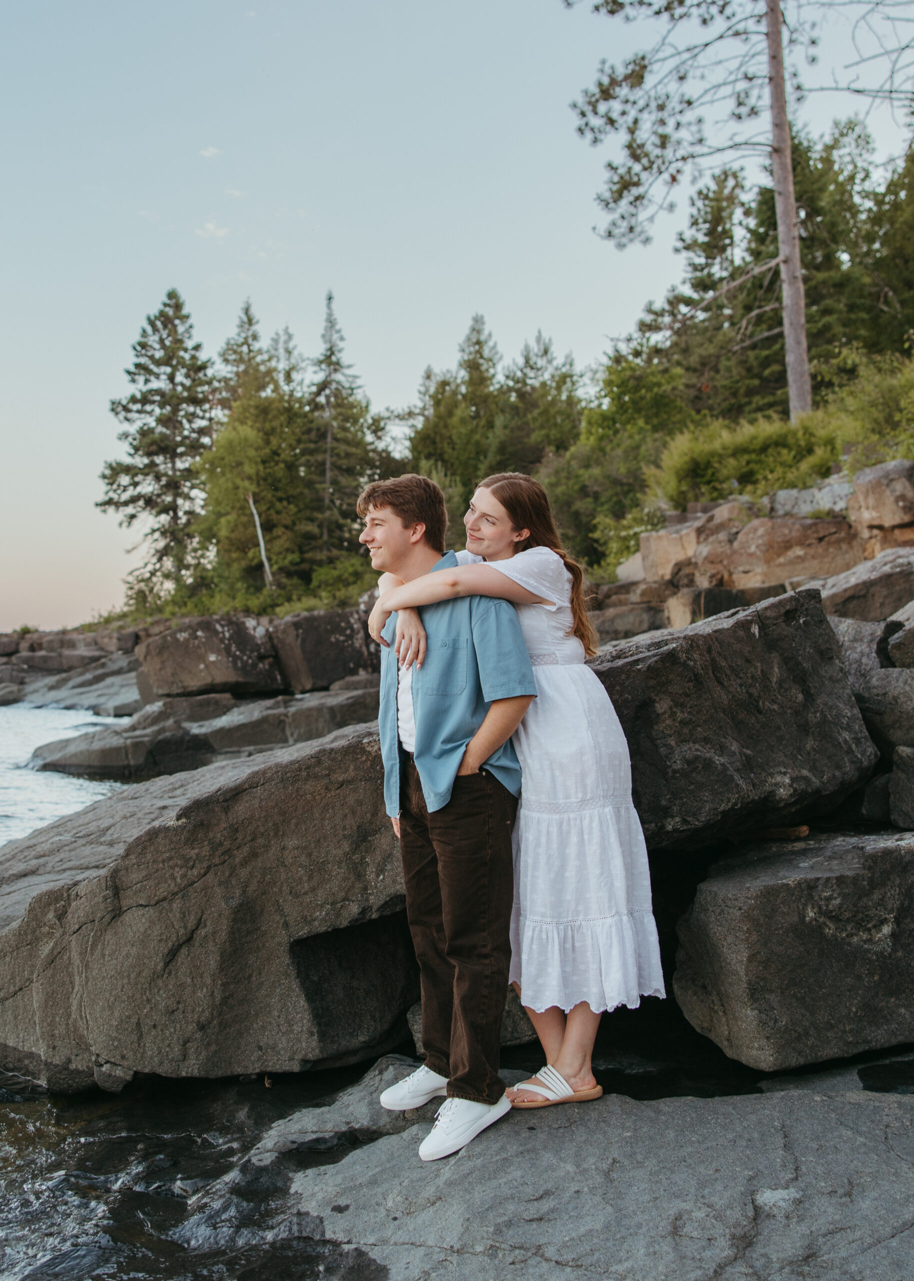 Couple embracing along the rocky coastline of Lake Superior.