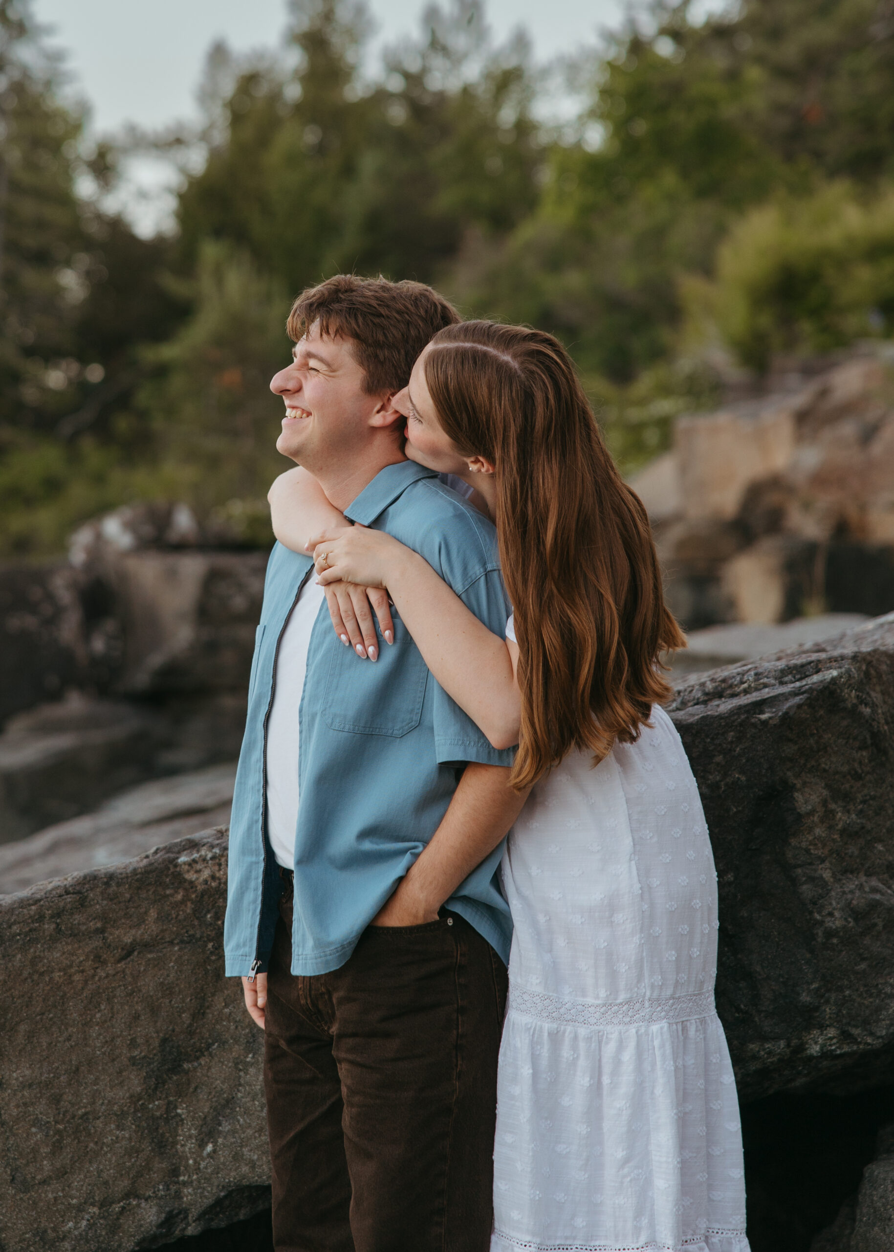 Couple embracing along the rocky coastline of Lake Superior.